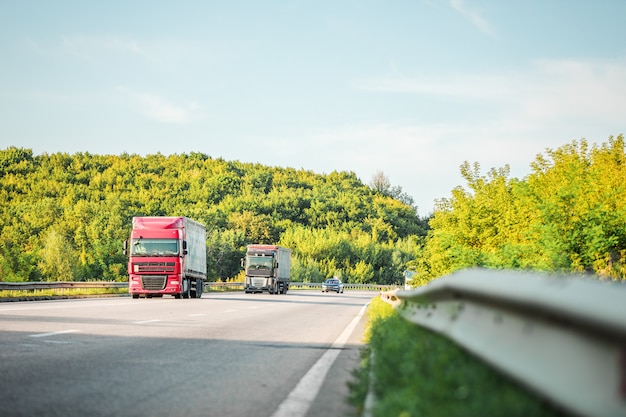 Arriving white truck on the road in a rural landscape at sunset