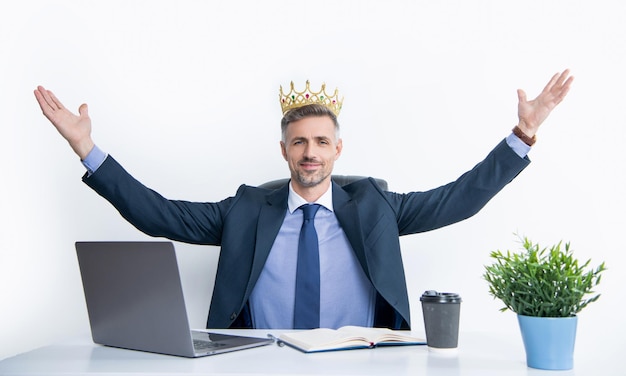 Arrogant mature businessman in suit wear crown at the office