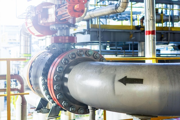 An arrow is drawn on a metal pipeline at a gas processing plant