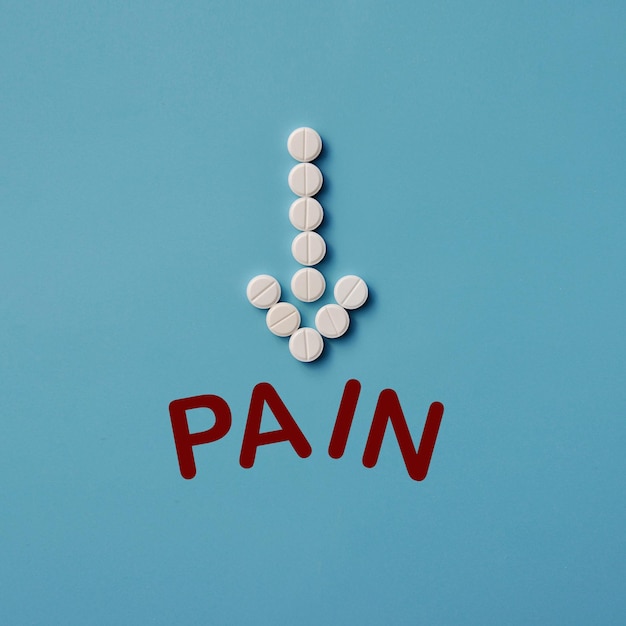 The arrow of the pills breaks the word pain. symbol of\
treatment and pain relief