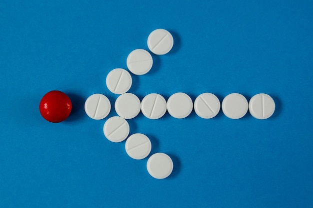 Arrow of pills indicates red pill, on blue, top view