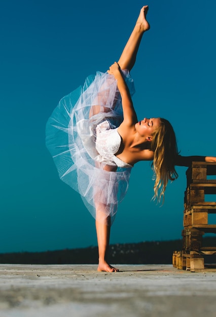 Photo art ballet young ballerina ballet dancer legsplit flexible girl doing split woman doing stretching up exercise outdoors