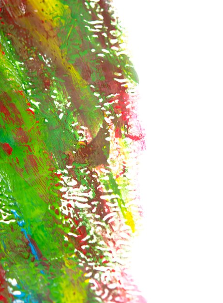 Art creative canvas with drawn lines of blue, yellow green, red paint. Drawing painted with gouache paints of different colors on white surface. Painting movement close-up. Multi-colored paint strokes