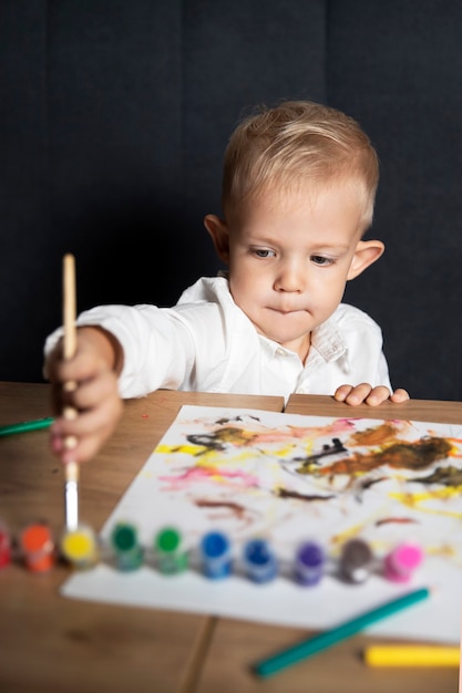 Art Creativity. A boy in a shirt draws with paints. Drawing lesson. Artist.