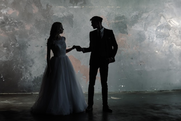 Foto foto in studio d'arte di una coppia di sposi, silhouette dello sposo e della sposa su uno sfondo colorato