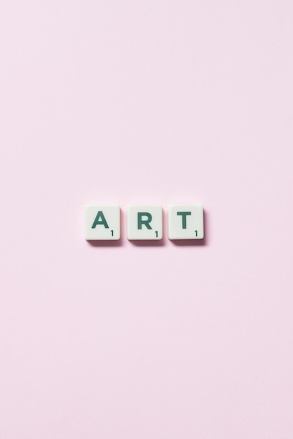 Art formed of scrabble tiles on pink background