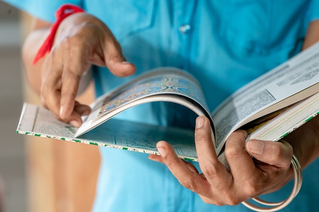 L'uomo d'arte tiene in mano il libro d'arte thailandese e trova l'ispirazione per il suo lavoro.