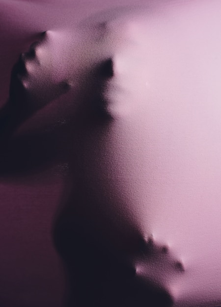 Art photo of a female silhouette breaking through the fabric.