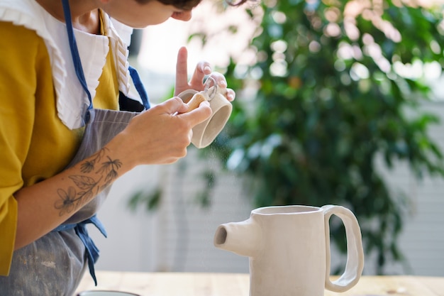 Art for recreation pottery handmade courses young woman concentrated on shaping and modeling jug