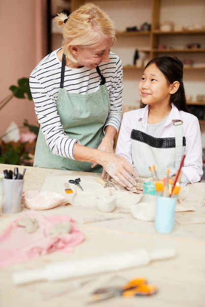 Insegnante di arte che aiuta ragazza asiatica