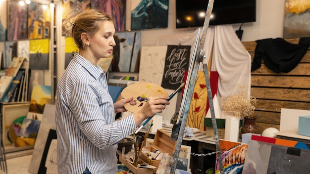 Foto arte una giovane donna dipinge un quadro in un laboratorio