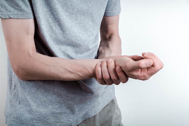 arthritis. a man holds his wrist in pain. sprain.
