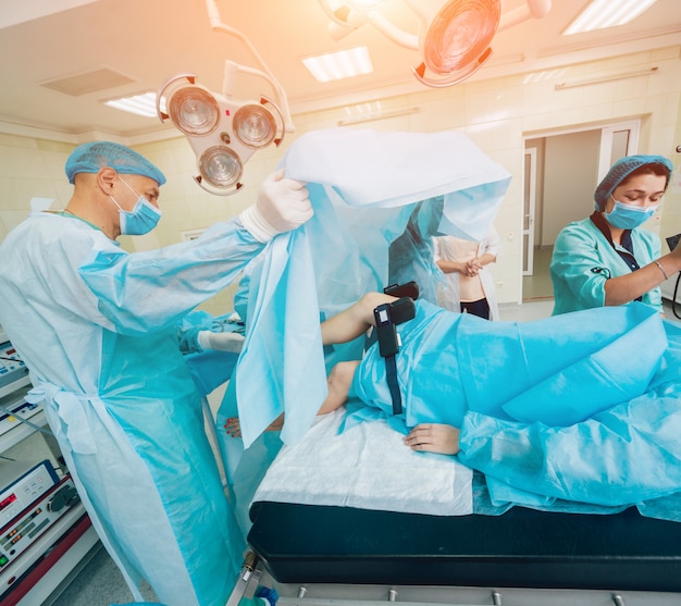 Артроскопическая хирургия. хирурги-ортопеды в совместной работе в операционной с современными артроскопическими инструментами. хирургическая операция на колене.