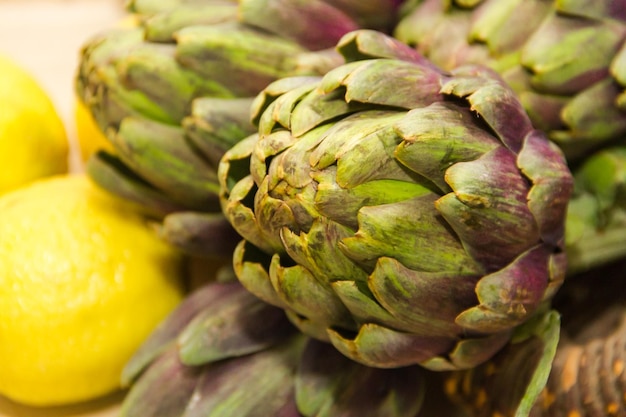 Artichokes cooked with lemon and salt on rustic wooden background