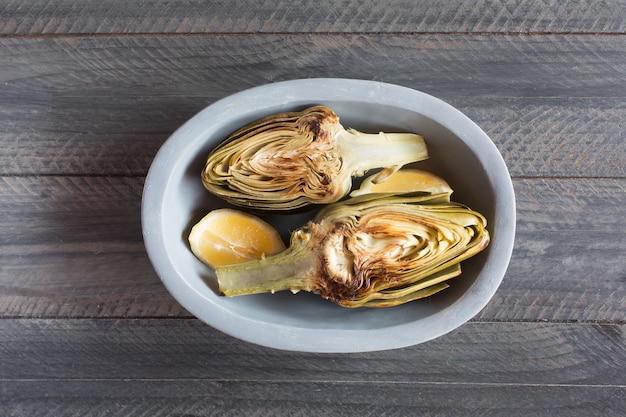 Artichokes and lemons on the plate. This product has one of the highest antioxidant capacities