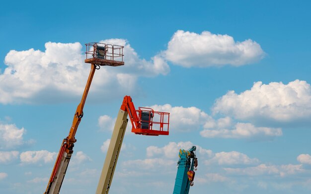 Piattaforma a braccio articolato. piattaforma aerea elevatrice. ascensore telescopico contro il cielo blu. autogru mobile in affitto e vendita. servizio di manutenzione e riparazione di sollevatori idraulici a braccio. concessionaria gru.