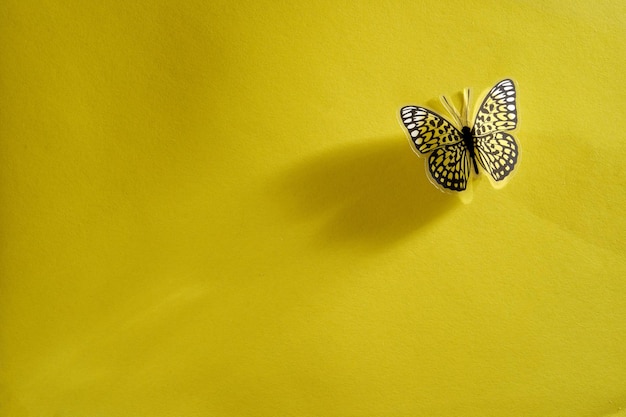 Photo artificial butterfly on yellow background