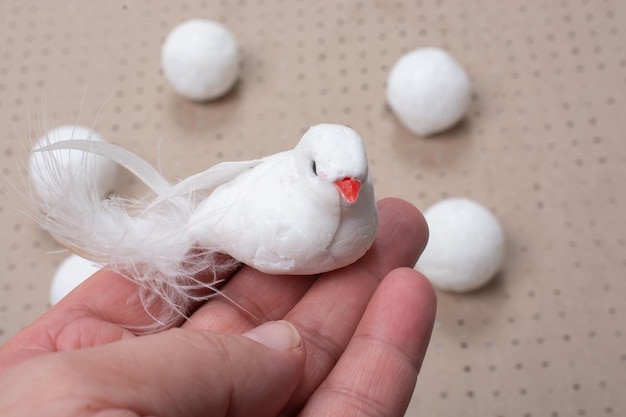 Artificial feather bird with white balls beside