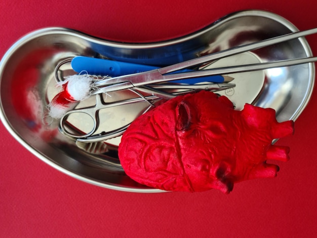 Artificial heart and medical instruments on operating table closeup