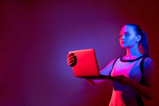 Artificial intelligence Futuristic technology Cyber security Cyborg woman with laptop in pink blue neon light isolated on purple copy space background