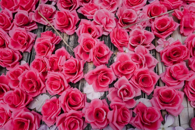 Artificial pink roses made from fabric decorated on wooden board background romance backdrop