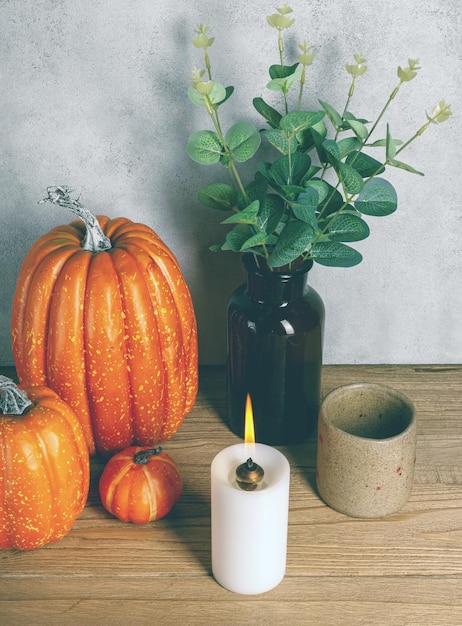 Artificial pumpkin with burning candle on wooden table Moody Style Halloween concept Copy space