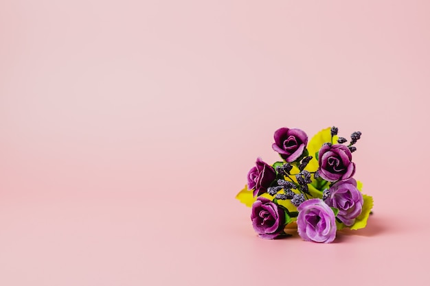 Bouquet di rose viola artificiali su sfondo rosa per amore e concetto di san valentino