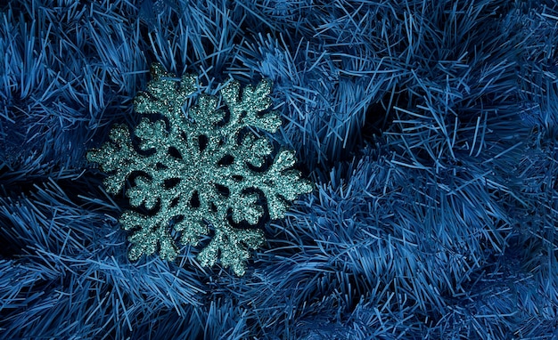 Artificial snowflake on a blue tinsel background christmas tree decoration decor wallpaper top view