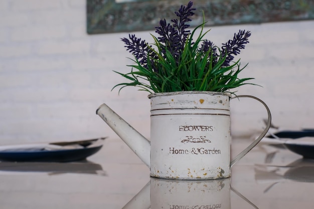 Artificial violet flowers in a white vase