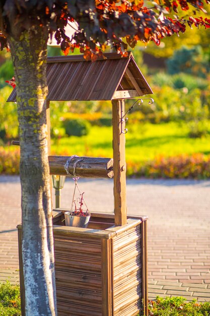 Artificial well with a bucket for flowers in the garden