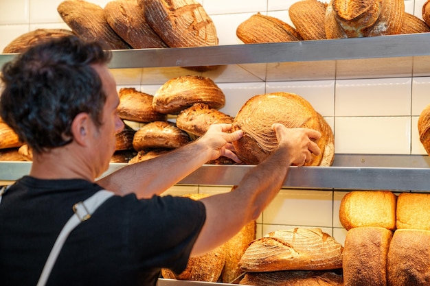 Foto panettiere artigianale che prepara pane caldo appena sfornato pronto per gli scaffali