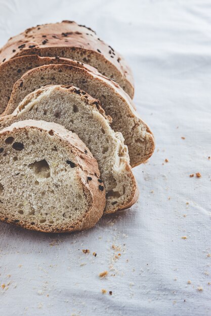 Artisan bread sliced on white cloth napkin.