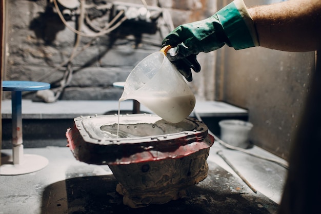 Artisan craftsman create mask based on plaster cast gypsum mold
and plastic mask sculpting