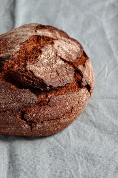 Pane azzimo scuro artigianale rosolato su fondo di lino blu