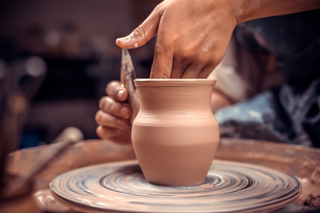 La ragazza artigiana mostra il processo di realizzazione di piatti in ceramica utilizzando la vecchia tecnologia.