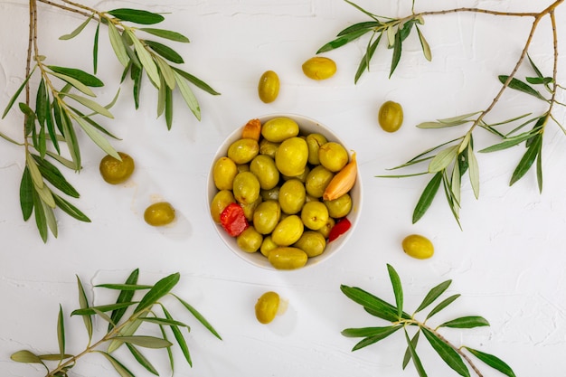 Artisan olives (canned in extra virgin olive oil, vinegar, spices) with red peppers and garlic. Appetizer concept.