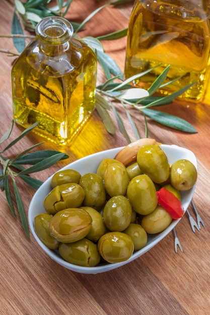 Artisan olives with red peppers and garlic on wooden board 