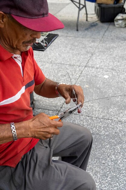 Artisan on the street making bicycle figurines with wire handmade metal figurines mexico