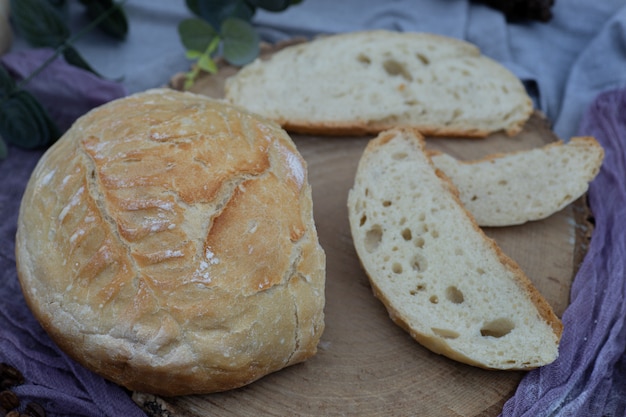 Artisanaal broodbroodje dat op tafelkleed in tuin wordt gesneden