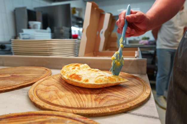 Photo artisanal baker prepares fresh georgian khachapuri in a cozy bakery kitchen during morning hours