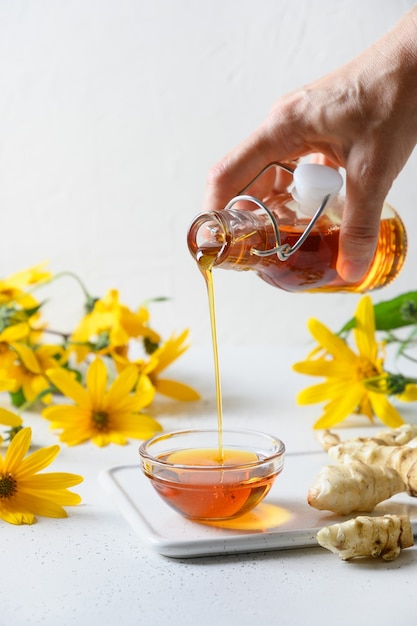 Artisjoksiroop van Jeruzalem in kom bloemen en wortel gieten