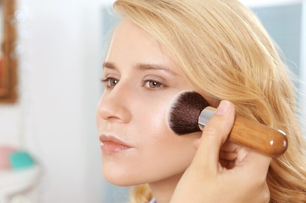 Artist applying blush with makeup brush