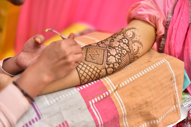 Foto artista che applica un tatuaggio di henna sulle mani delle donne