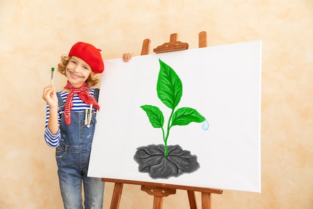 Artist child painting the picture on canvas.