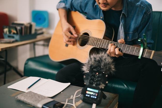 Artist composer in work process A songwriter or composer songwriter thinking and writing notes lyrics in book man playing live acoustic guitarconcept for musician creative