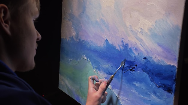 芸術家のコピー家が海の船で海の景色を描く職人の装飾家がアクリル油絵の具で青い海をボートの帆として描く