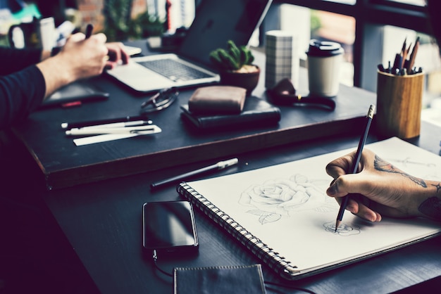 Artist drawing a rose by pencil