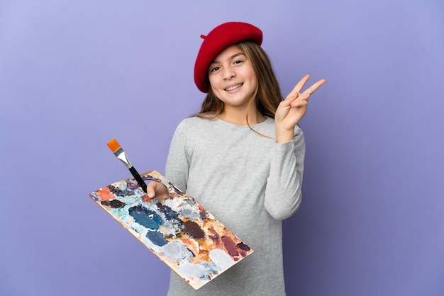 Девушка-художник над изолированной улыбкой и показывает знак победы