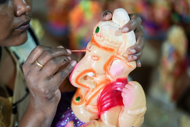 Artist gives finishing touches on an idol of the Hindu god Lord Ganesha