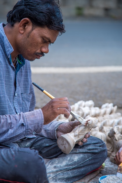 Artist gives finishing touches on statue of Bull at workshop for Bail Bull Pola Festival